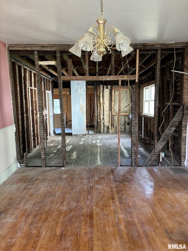 misc room featuring wood-type flooring and an inviting chandelier