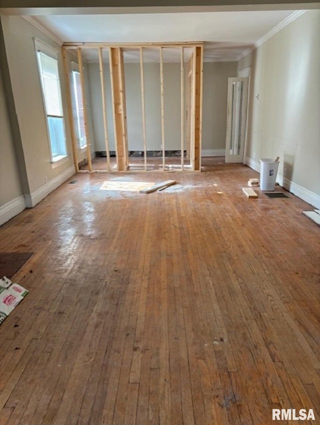 empty room with ornamental molding and hardwood / wood-style floors