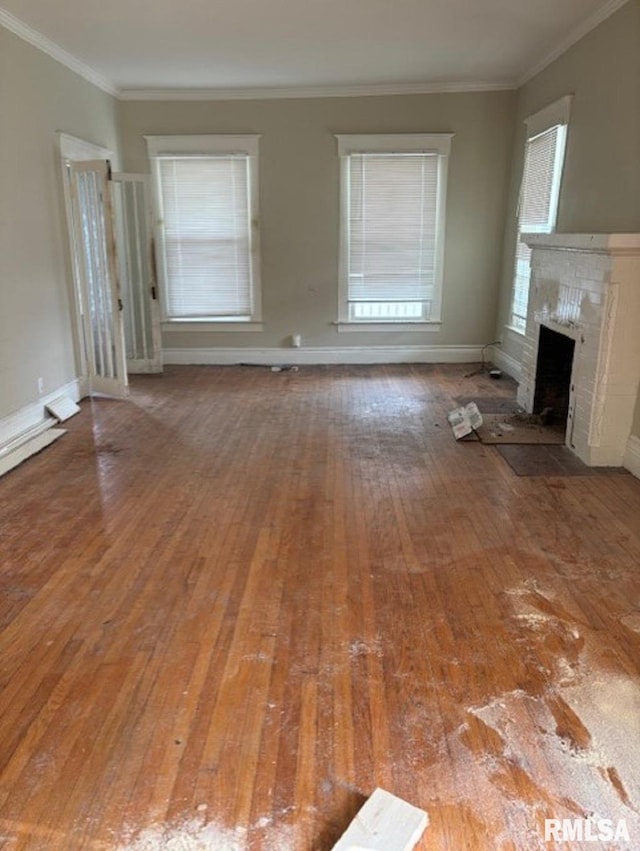 unfurnished living room featuring hardwood / wood-style floors, plenty of natural light, and crown molding