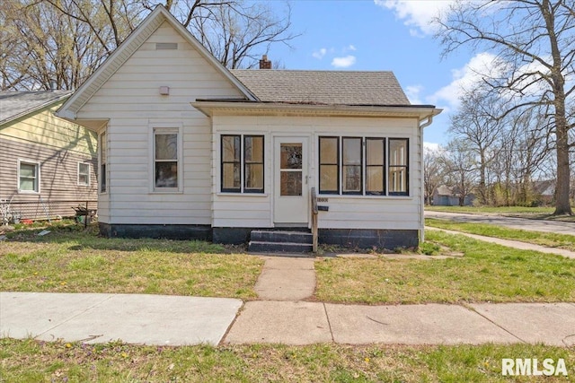 bungalow-style home with a front yard