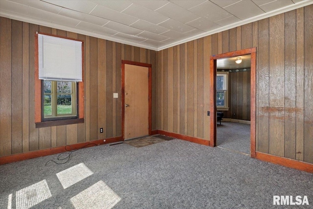 empty room with dark colored carpet and ornamental molding