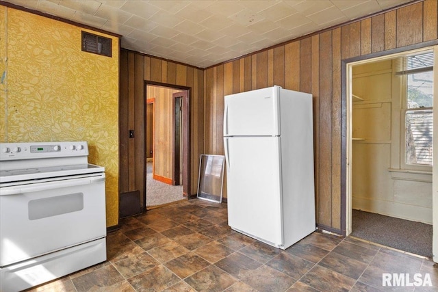 kitchen featuring white appliances and wooden walls