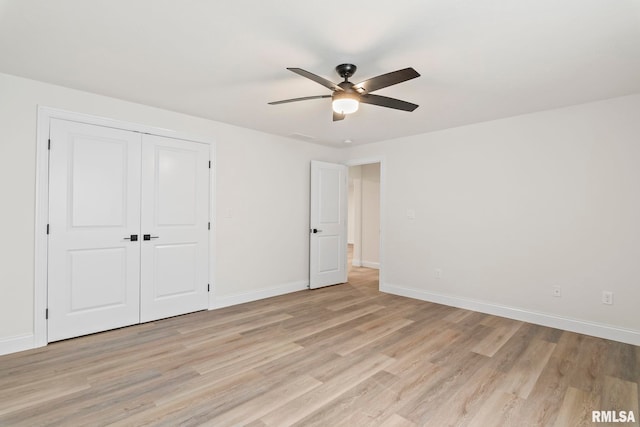 unfurnished bedroom with ceiling fan, light hardwood / wood-style flooring, and a closet