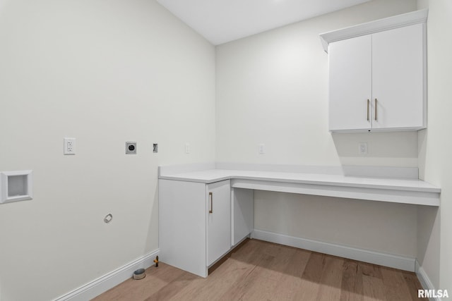 washroom with light hardwood / wood-style flooring, hookup for an electric dryer, cabinets, and gas dryer hookup