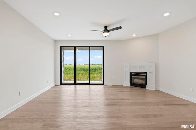 unfurnished living room with light wood-type flooring and ceiling fan