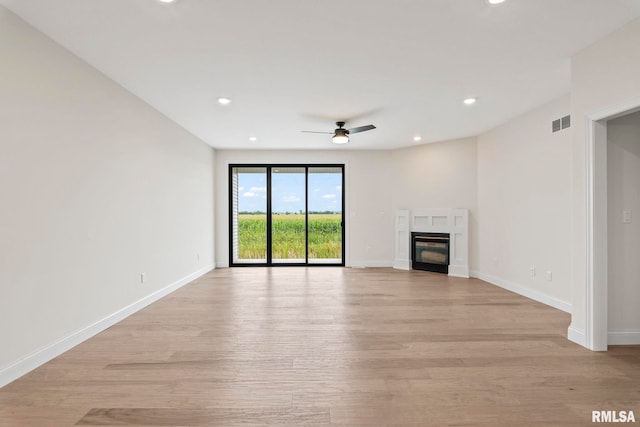 unfurnished living room with ceiling fan and light hardwood / wood-style flooring