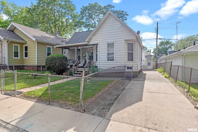 bungalow with covered porch and a front lawn