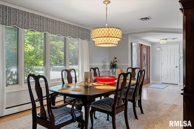 dining space featuring light hardwood / wood-style floors and ornamental molding