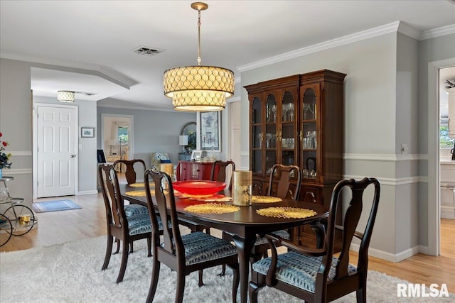 dining space featuring light hardwood / wood-style floors and ornamental molding