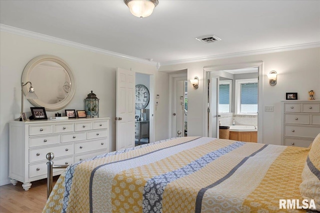 bedroom with light hardwood / wood-style floors, crown molding, and ensuite bath