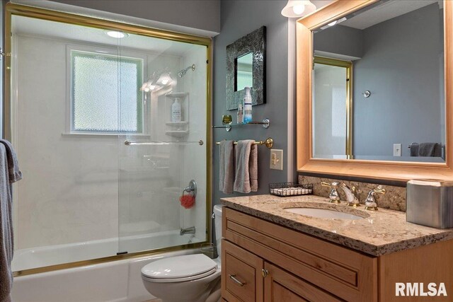 full bathroom featuring vanity, toilet, and bath / shower combo with glass door