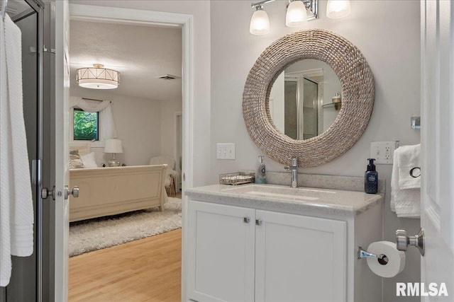 bathroom with hardwood / wood-style flooring, vanity, and a textured ceiling