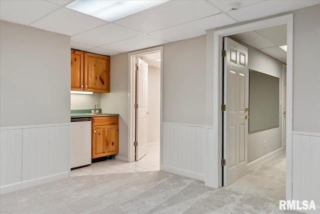 bar featuring dishwasher, light carpet, a drop ceiling, and sink