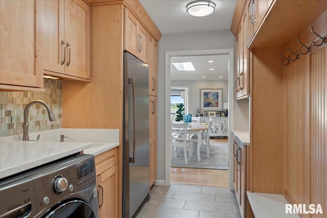 laundry room featuring a textured ceiling, cabinets, sink, and light hardwood / wood-style flooring