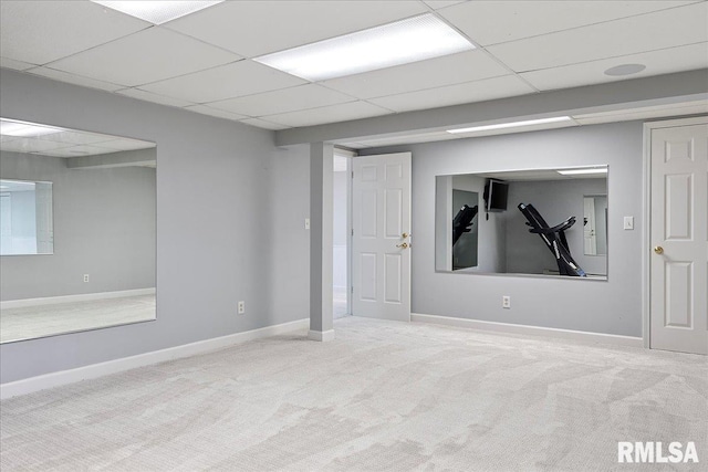 basement featuring light carpet and a drop ceiling