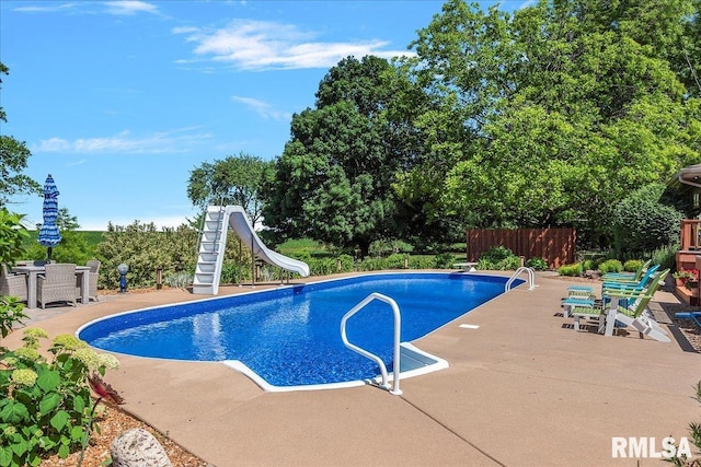 view of swimming pool with a patio area and a water slide