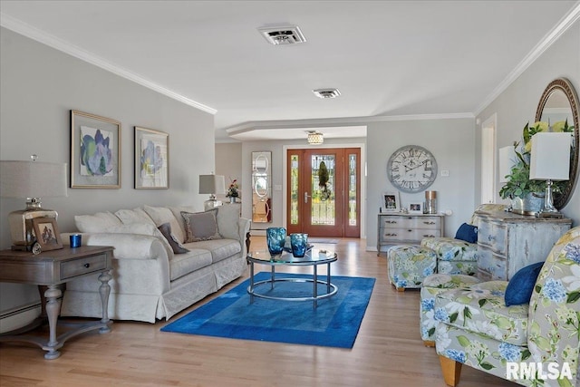 living room featuring light hardwood / wood-style flooring and crown molding