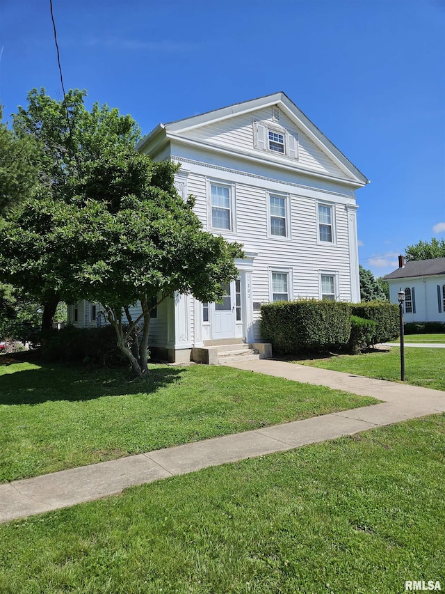 greek revival house featuring a front yard