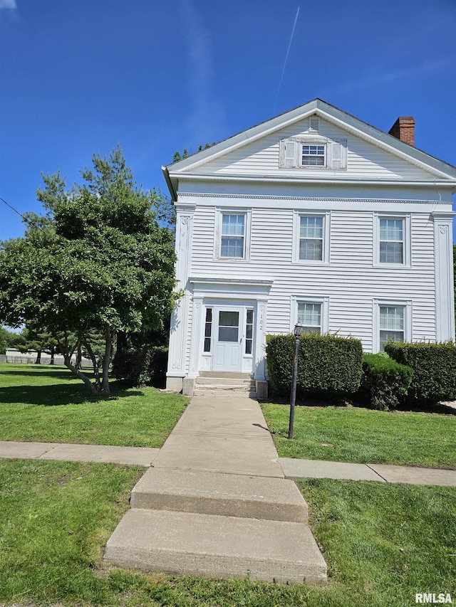 neoclassical home with a front lawn