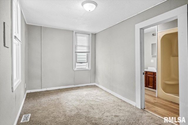 carpeted empty room featuring a textured ceiling