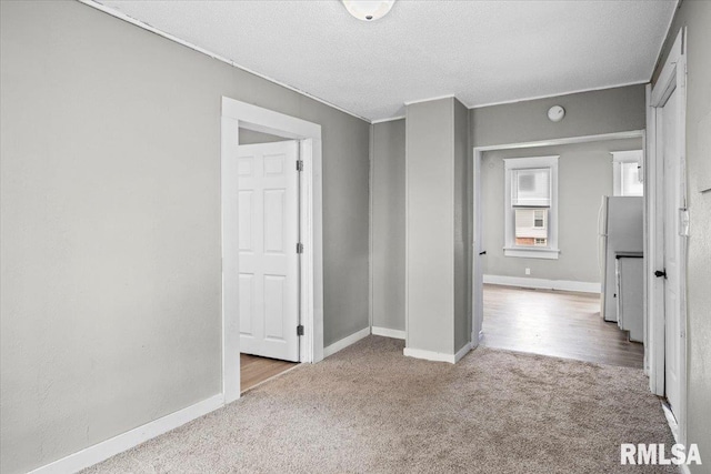 empty room with a textured ceiling and light colored carpet