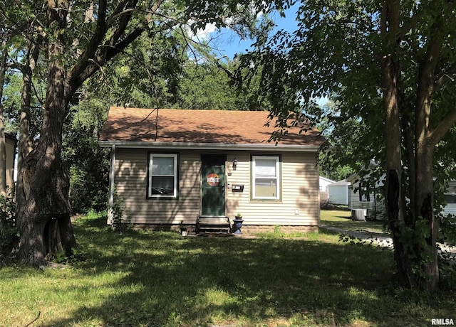 view of front of property with a front yard and central AC