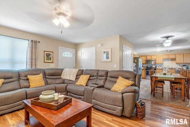 living room with ceiling fan and light hardwood / wood-style floors