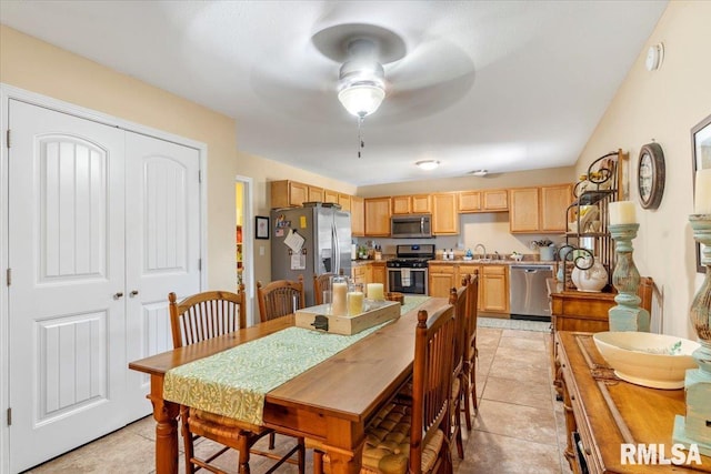 tiled dining space with ceiling fan and sink