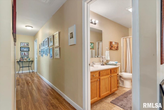 hall with sink and light wood-type flooring