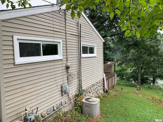 view of side of property with central AC and a yard