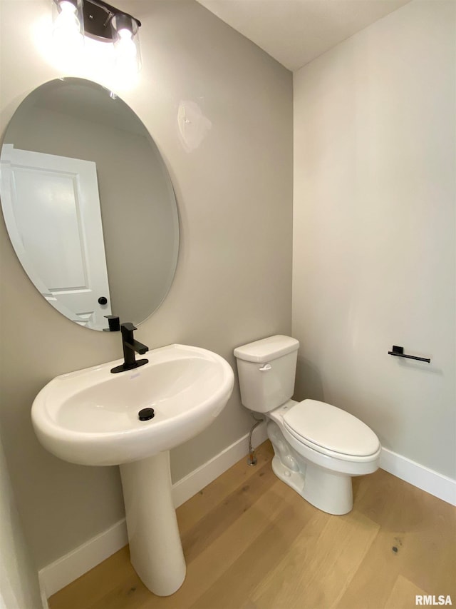 bathroom featuring wood-type flooring and toilet