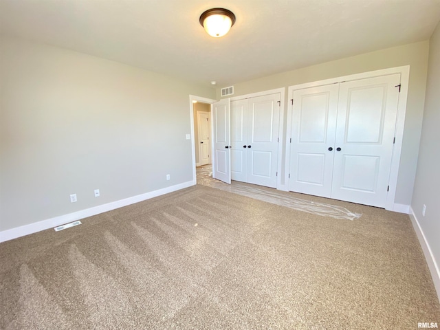 unfurnished bedroom with carpet flooring and multiple closets