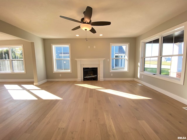 unfurnished living room featuring ceiling fan and light hardwood / wood-style floors