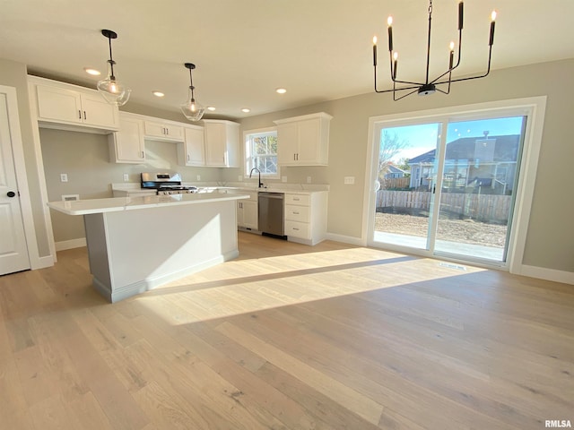 kitchen featuring white cabinetry, a center island, light hardwood / wood-style flooring, a notable chandelier, and appliances with stainless steel finishes