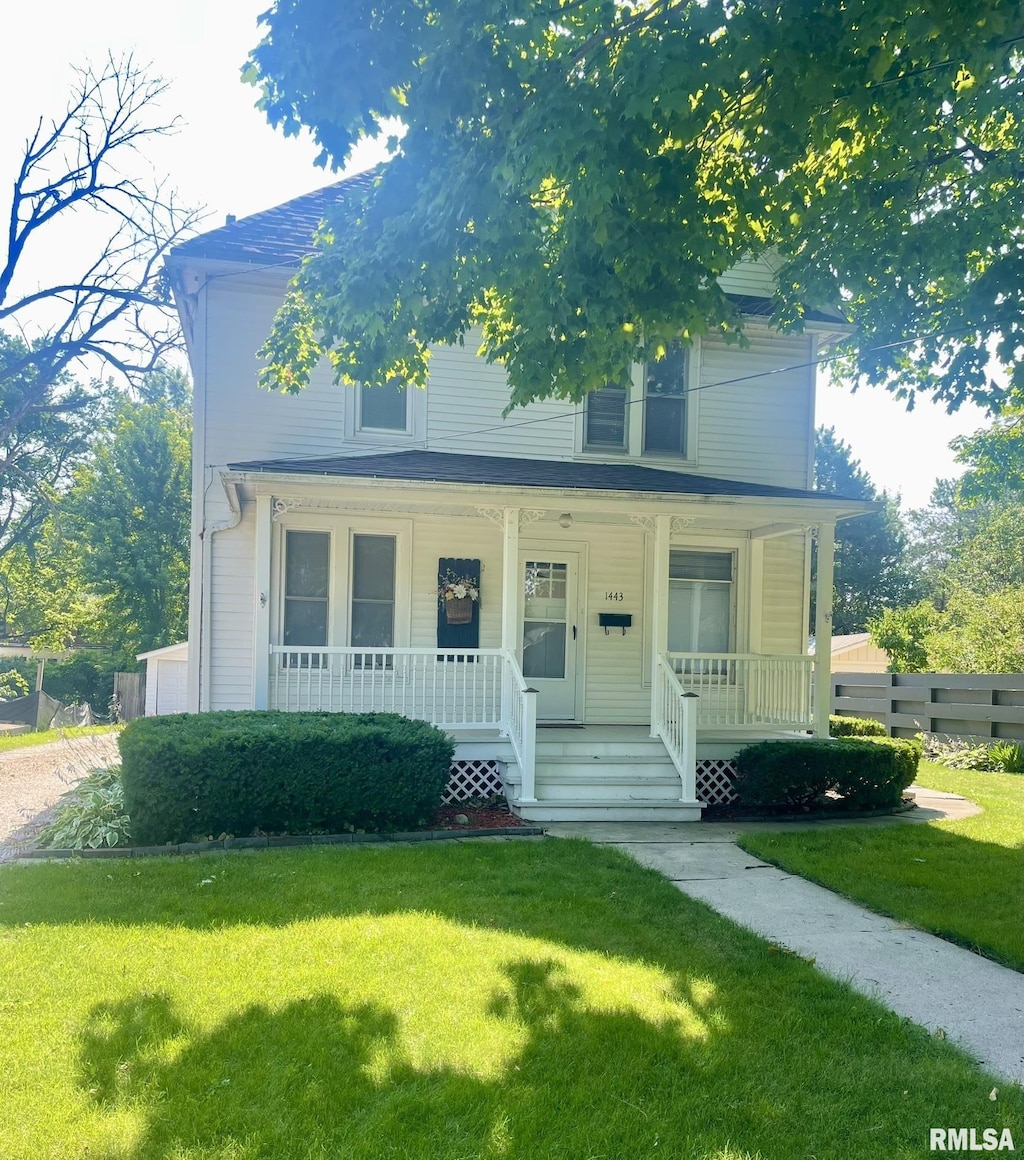 view of front facade with a front lawn and covered porch