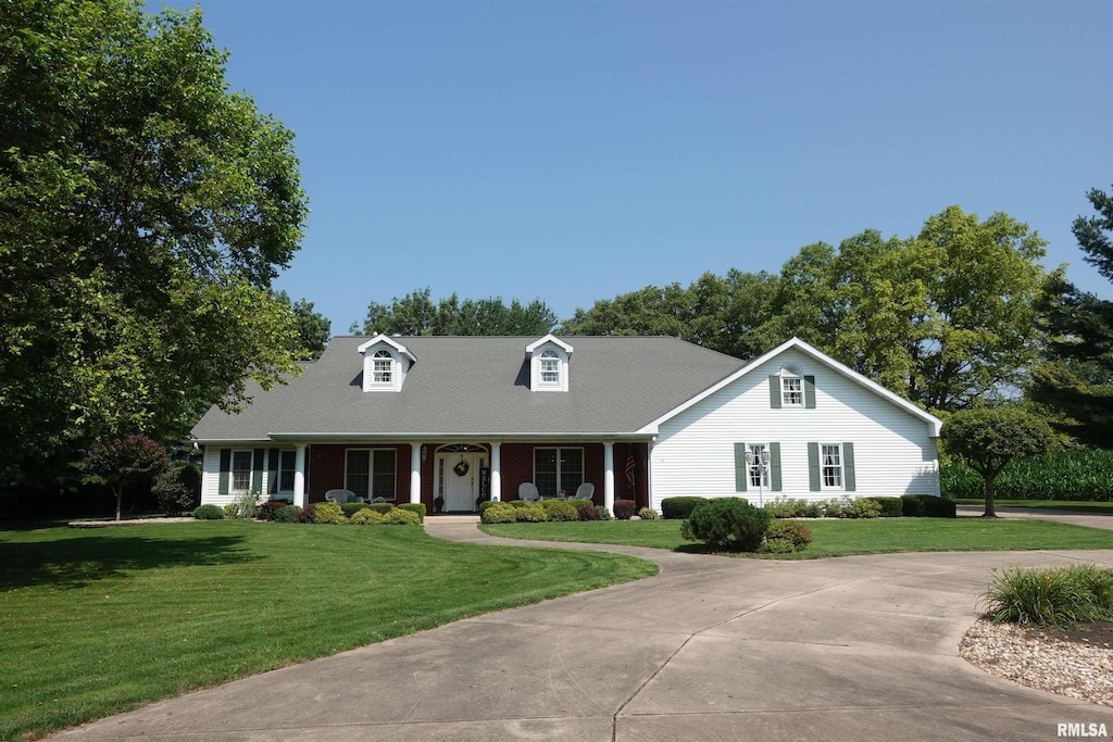 cape cod house with covered porch and a front yard