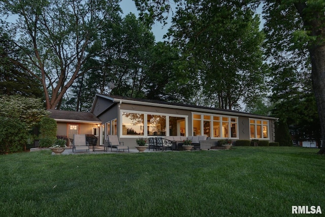 rear view of house featuring a lawn, an outdoor hangout area, and a patio