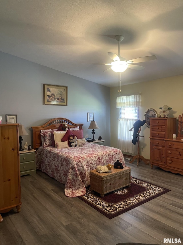 bedroom with a textured ceiling, ceiling fan, and dark hardwood / wood-style floors