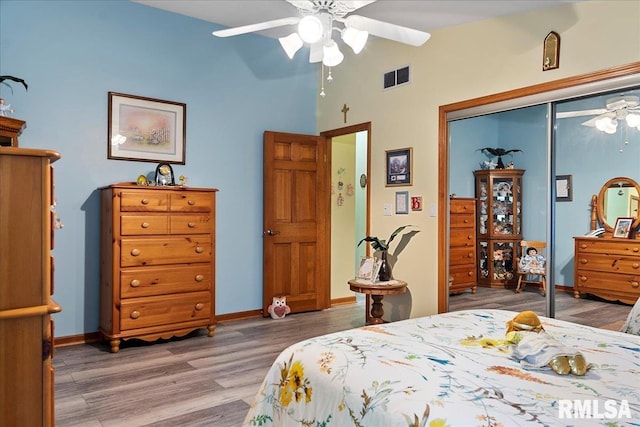 bedroom with a closet, hardwood / wood-style flooring, and ceiling fan