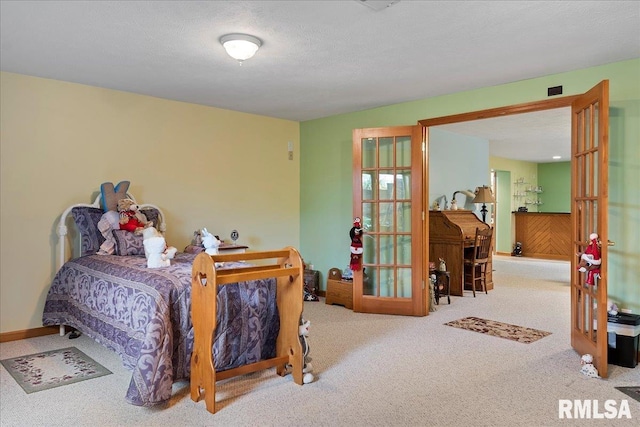 bedroom with french doors, a textured ceiling, and carpet