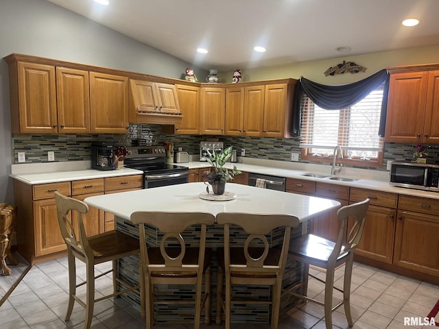 5001 Wildcat Run, Springfield, IL 62711 - kitchen featuring appliances with stainless steel finishes, a sink, a kitchen bar, light countertops, and lofted ceiling