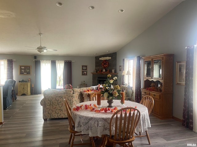 dining area featuring a brick fireplace, lofted ceiling, ceiling fan, and dark hardwood / wood-style floors