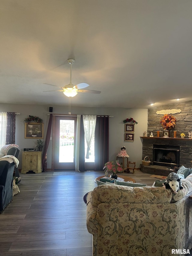 living room with a fireplace, wood-type flooring, and ceiling fan