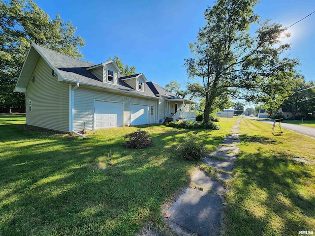 view of side of property with a garage, covered porch, and a lawn