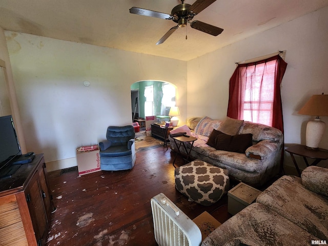 living room featuring dark wood-type flooring and ceiling fan