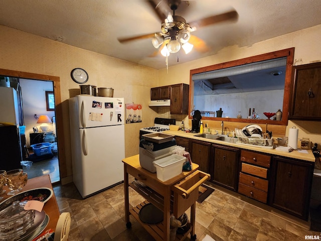 kitchen with white appliances, dark brown cabinets, a textured ceiling, sink, and ceiling fan