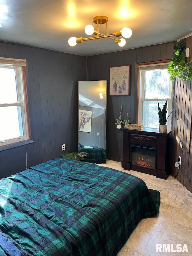 tiled bedroom with a notable chandelier and multiple windows