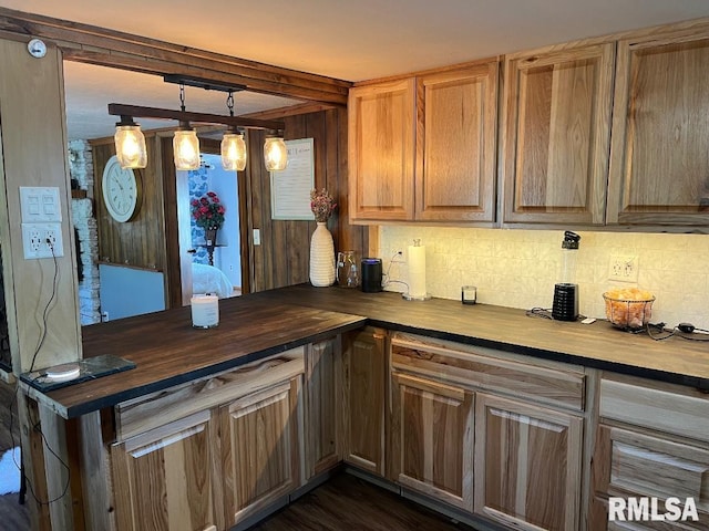 kitchen with dark wood-type flooring, hanging light fixtures, and butcher block counters