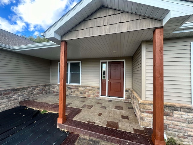 view of exterior entry featuring covered porch