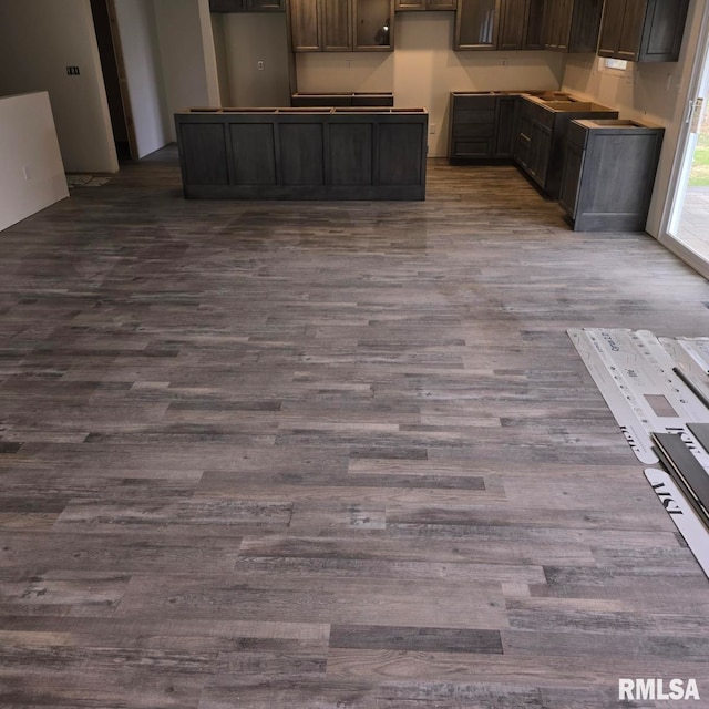 kitchen featuring dark hardwood / wood-style flooring and dark brown cabinetry